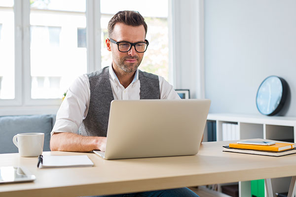 man using computer wearing glasses